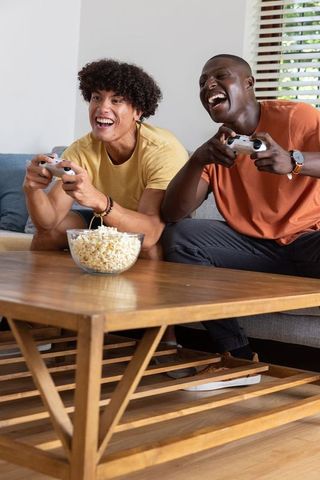 Joyful Friends Engaging in Video Gaming Session at Home
