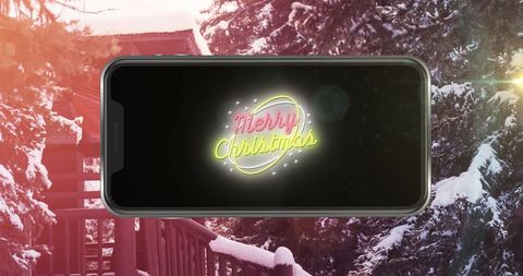Christmas Greeting on Smartphone with Winter Forest Backdrop