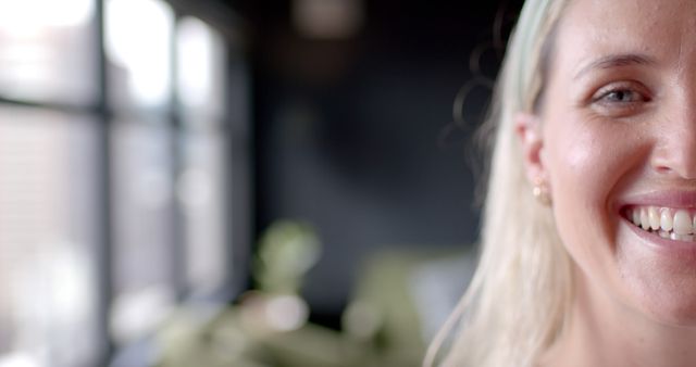 Closeup of Half Face of Smiling Woman with Blonde Hair and Ear Piercings - Download Free Stock Images Pikwizard.com