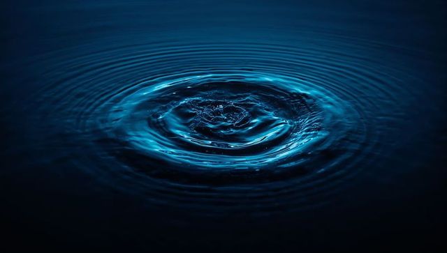 Rippling Waves: Impact of Water Droplet on Blue Surface Emphasizing Tranquility