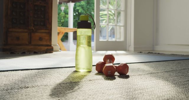 Image of bottle of water, weights and yoga mat prepared for exercising at home. active healthy lifestyle, exercising at home.