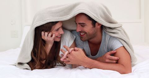 Happy Couple Enjoying Playful Moment Under Blanket
