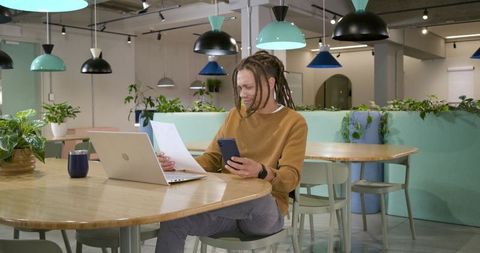 Professional working in coworking space with laptop and smartphone, minimalist workspace