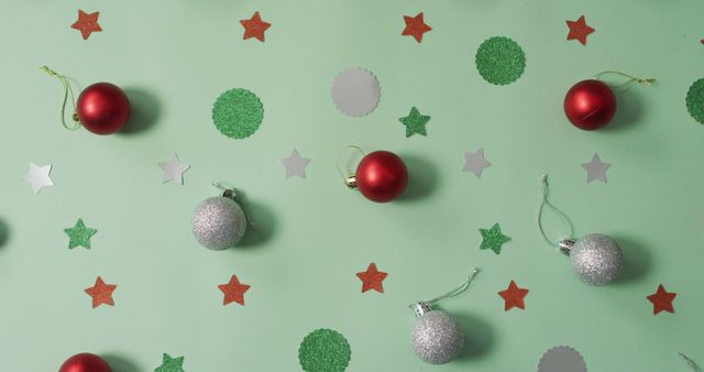 Christmas decorations with silver and red baubles on green background. christmas, tradition and celebration concept image.