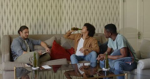 Friends Enjoying Casual Drink Smiles Warm Sofa Gathering