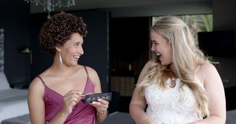 Bride and Bridesmaid Enjoying Wedding Day Preparations