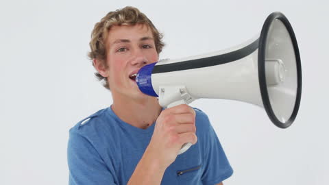Joyful Young Man Speaking Through Megaphone on White Background