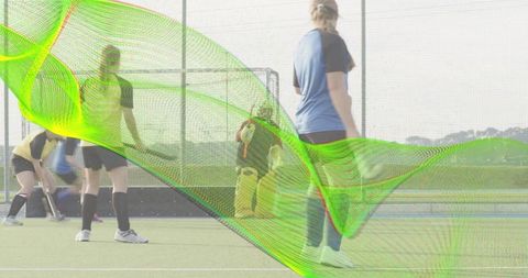 Women defending goal in field hockey with neon green overlay showing teamwork