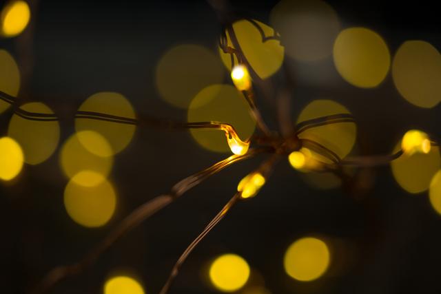 Close-up view of glowing rice lights creating a beautiful bokeh effect. Ideal for use in holiday and festive-themed designs, Christmas decorations, and cozy ambiance settings. Perfect for backgrounds, greeting cards, and promotional materials for seasonal events.