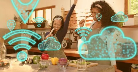 Two women dancing and cooking in smart kitchen with augmented reality cloud and WiFi icons