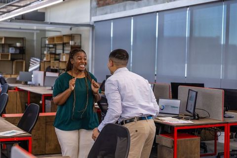 Diverse Coworkers Celebrating Success in Open Office