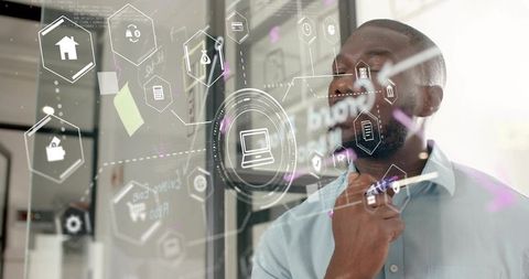 Professional studying and writing on glass with holographic tech icons for digital brainstorming