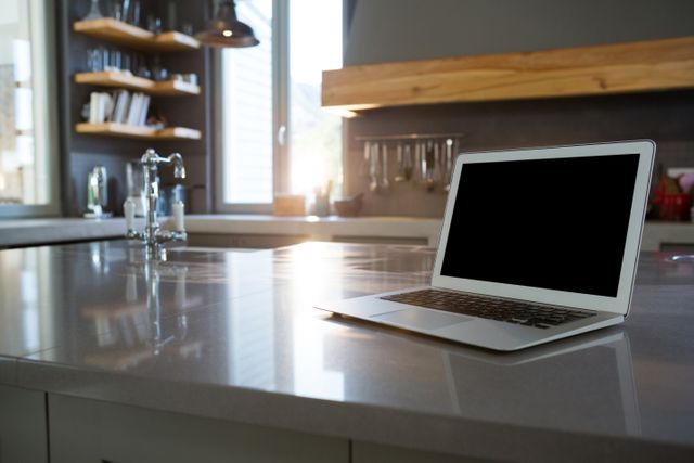 Laptop on kitchen counter at home