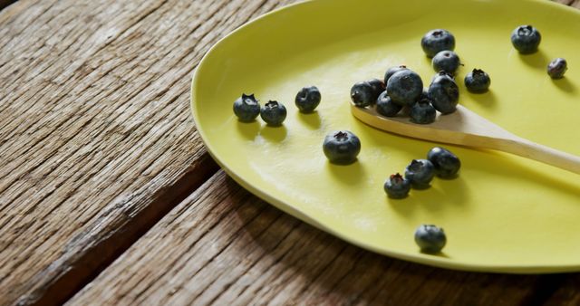 Fresh Blueberries on Modern Yellow Plate with Wooden Spoon - Download Free Stock Images Pikwizard.com