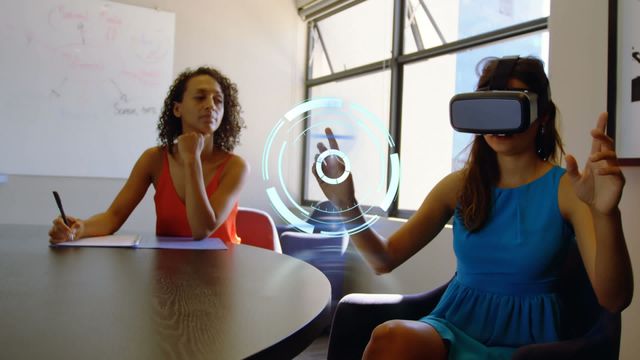 This video captures two businesswomen engaged in a work meeting. One is using VR technology, highlighted by a graphical interface overlay, while the other takes notes. Ideal for illustrating modern work environments, technological innovation in business, and collaborative team interactions.