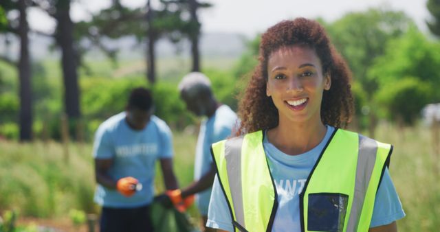 Smiling Young Volunteer in High-Visibility Vest at Outdoor Community Service Project - Download Free Stock Images Pikwizard.com