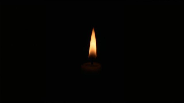 Solitary Candle Flame Burning in Darkness Casting Warm Glow Minimalist Chiaroscuro