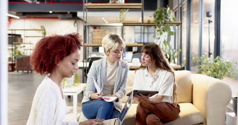 Diverse Team of Female Coworkers Collaborating in Office Lounge