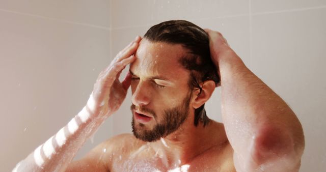 Image shows a man in the process of taking a shower, highlighting personal hygiene and relaxation. Use for promoting shower products, grooming habits, personal care routines, and lifestyles. Suitable for articles on health and hygiene, shower gel advertisements, and self-care blogs.