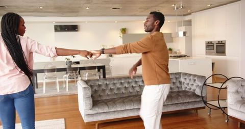 Joyful Couple Dancing in Stylish Open-Plan Living Space