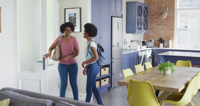 Mother and Daughter Arriving Home in Modern Kitchen - Download Free Stock Images Pikwizard.com