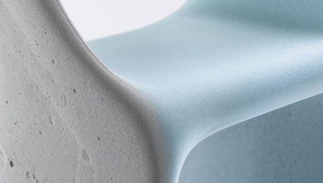 Curved junction of pale blue molded surface and rough light-grey concrete minimal texture