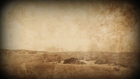 Sepia rural landscape evoking vintage farmland with outbuilding, tree grove and dirt trail