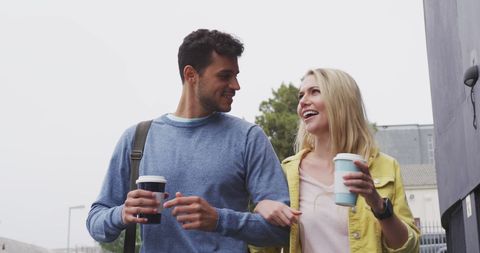 Happy Couple Walking with Takeaway Coffee in City Streets