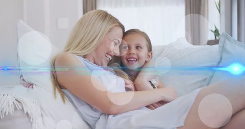 Joyful Mother and Daughter Relaxing on Comfortable Sofa