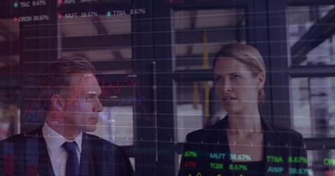 Traders analyzing market data on transparent digital display in modern office