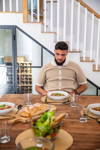 Man Eating Around Modern Kitchen With Pasta and Salad Feast