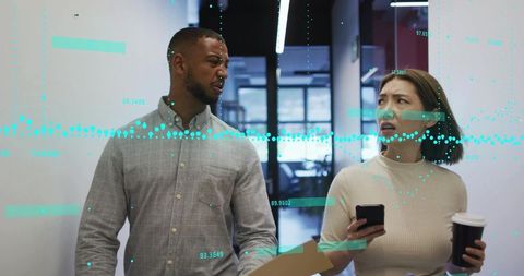 Coworkers walking through office holding phone, coffee and folder with data overlay