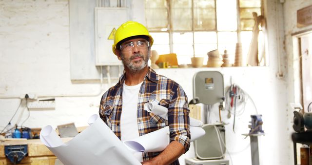 Focused Carpenter Examining Design Plans in Bright Workshop - Download Free Stock Images Pikwizard.com