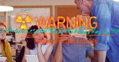 Creative team collaborating with tablets and laptops with radioactive warning overlay