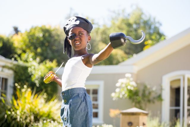 African American sister wearing pirate costume, holding a hook and a jar. She has dark brown eyes, black hair under her hat, and hoop earrings, unaltered