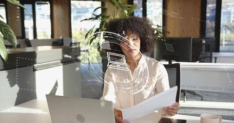 Focused Businesswoman Analyzing Documents in Modern Office Setting