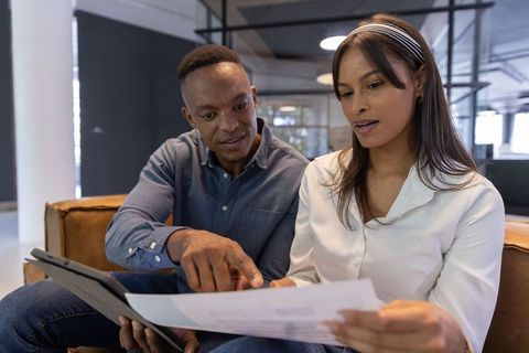 Coworkers collaborating in modern office setting with technology