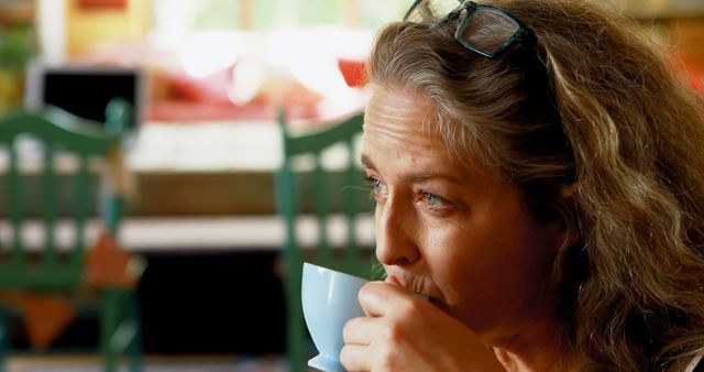 Mature Woman Sipping Coffee in Cozy Cafe - Download Free Stock Images Pikwizard.com