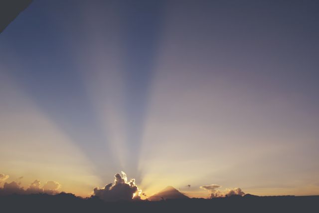 Sunbeams radiate from the horizon during a serene sunrise. Ideal for projects emphasizing nature, tranquility, or morning scenes. Suitable for use in travel brochures, meditation apps, and environmental campaigns.