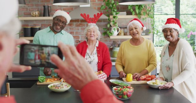Group of cheerful senior friends celebrating Christmas together in modern kitchen. They are preparing food, chopping vegetables, while wearing Santa hats and festive accessories. Ideal for holiday season promotions, social gatherings, cooking shows, and festive community events.