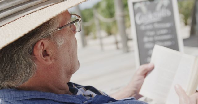 Senior Man Relaxing with Book Outdoors on Sunny Day - Download Free Stock Images Pikwizard.com