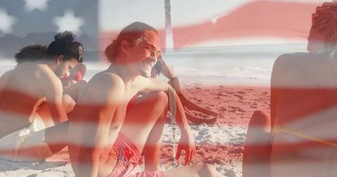 Smiling friends relaxing on sunny beach with American flag overlay