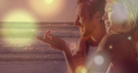 Couple Embracing at Sunset on Beach with Warm Lens Flare, Bokeh and Golden Hour Glow