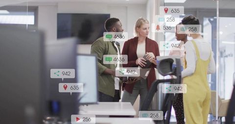 Diverse team collaborating around laptop in modern open office with social media overlays