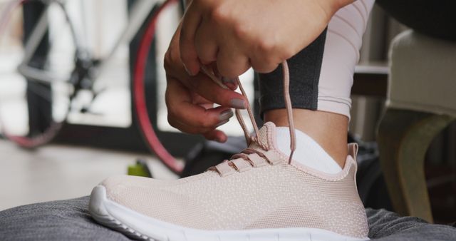 Image of foot of plus size african american woman in sport clothes tying shoes. active healthy lifestyle, exercising at home.