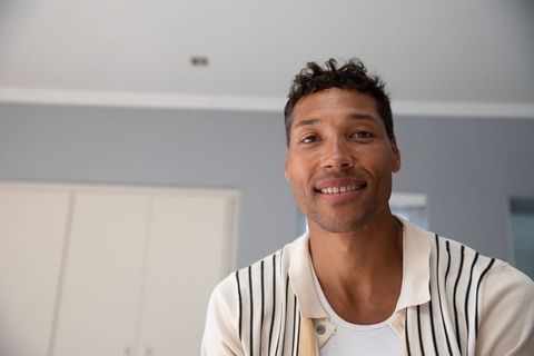 Confident young adult man smiling in minimalist interior setting