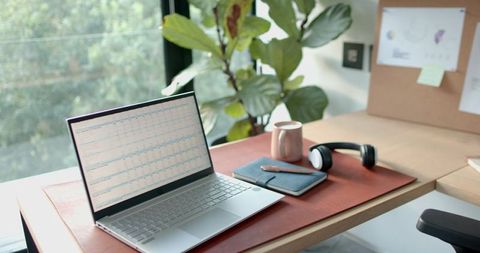 Modern Workspace with Laptop and Accessories by Sunny Window