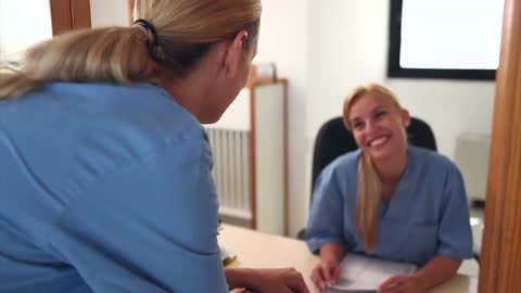 Friendly Interaction Between Receptionist and Nurse in Hospital