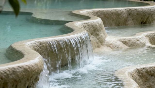 Cascading travertine terraces with turquoise pools and terraced basins at thermal springs