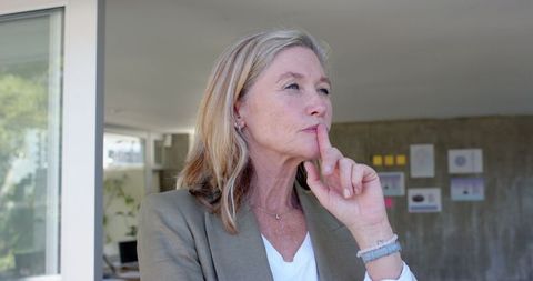 Professional woman analyzing office space with thoughtful gaze